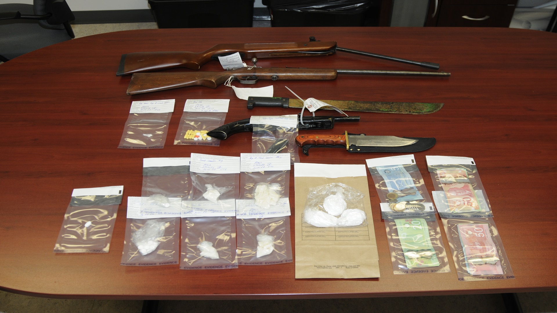 Seized drugs and firearms displayed on a table